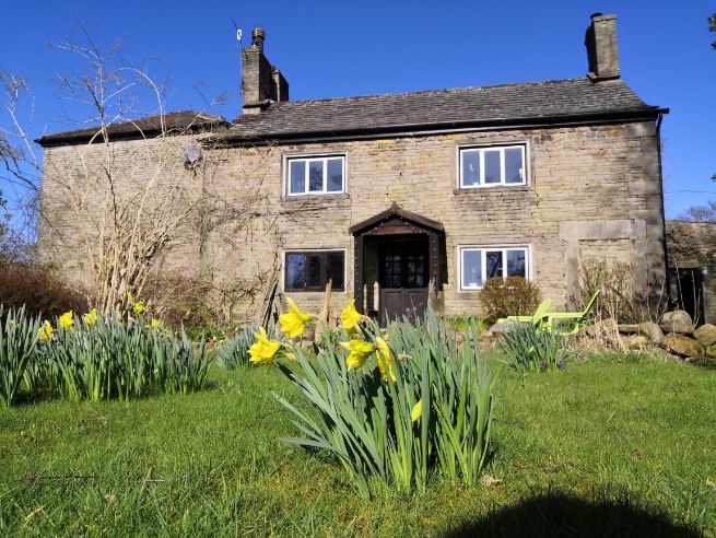 Daffodils in foreground of Goytside stone farmhouse